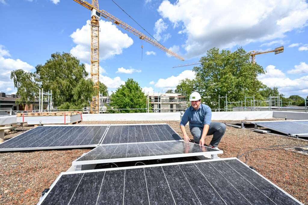 Photovoltaik auf dem Dach, Geothermie aus dem Boden - SWB-Projektleiter Damian Hoy schaut sich die Module an und stellte dem VdW Rheinland Westfalen das moderne Klimakonzept des Wohnquartiers „EliQ“ vor